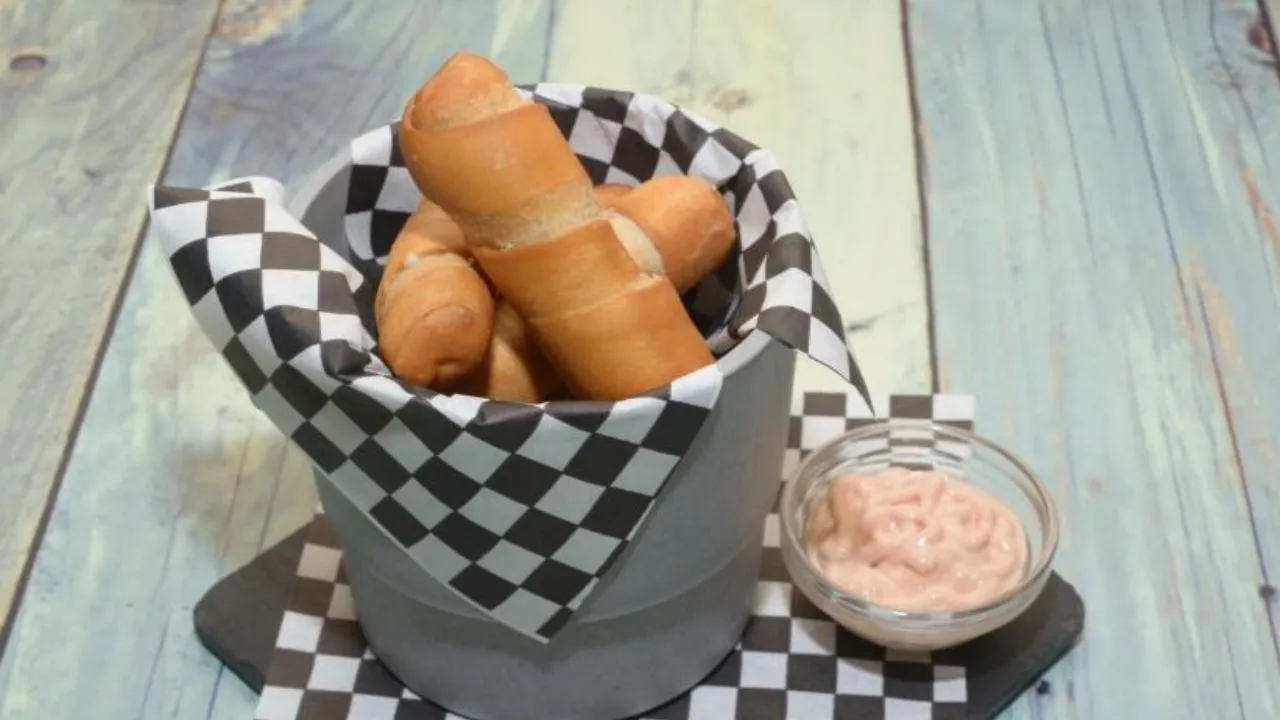 Bucket of tequeños with sauce